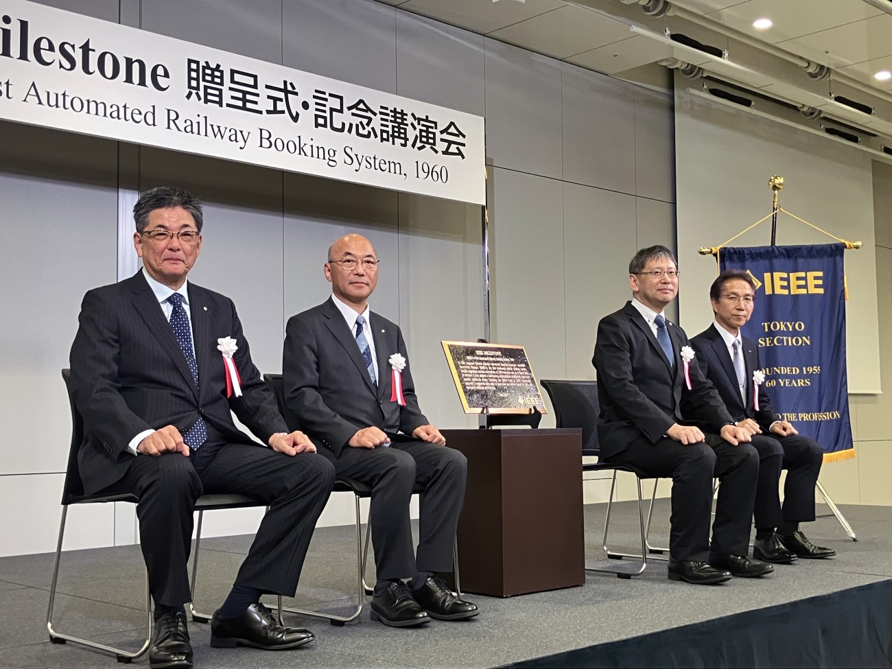 受贈者を代表して、（左から）鉄道総合技術研究所 理事長 渡辺郁夫氏、鉄道情報システム 代表取締役社長 池田孝行氏、日立製作所 執行役専務 永野勝也氏の3名に、IEEEリージョン10 歴史委員長 尾上孝雄氏から銘板が贈呈された